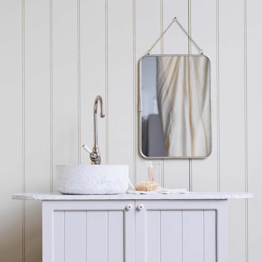 round white marble sink on bathroom vanity with nickel framed mirror
